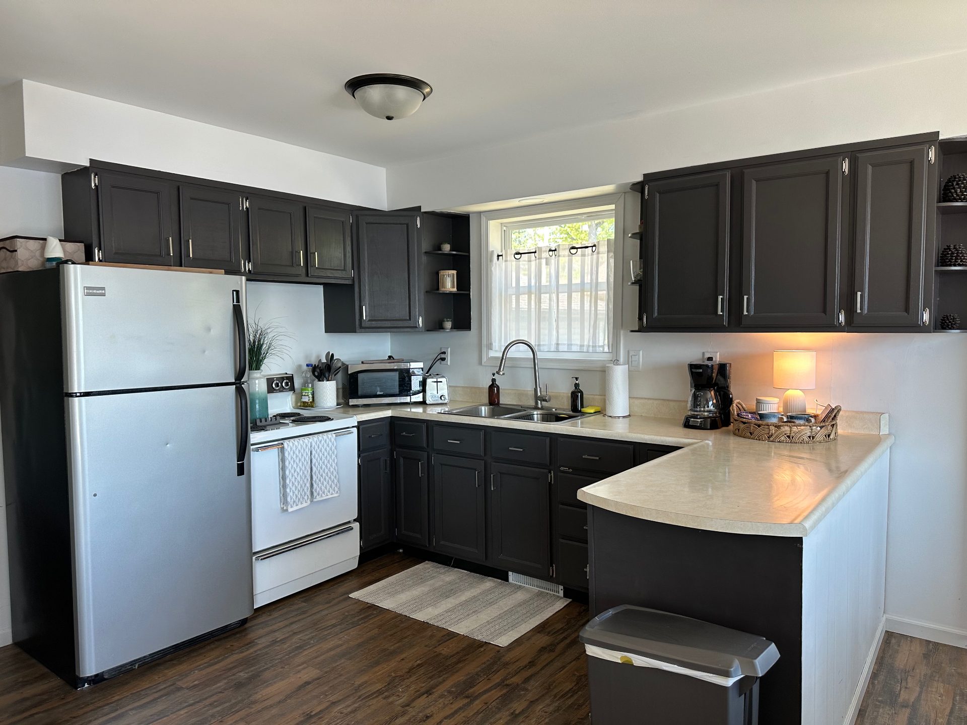 Fully equipped kitchen at Oscoda Lakehouse with charcoal cabinetry and breakfast bar