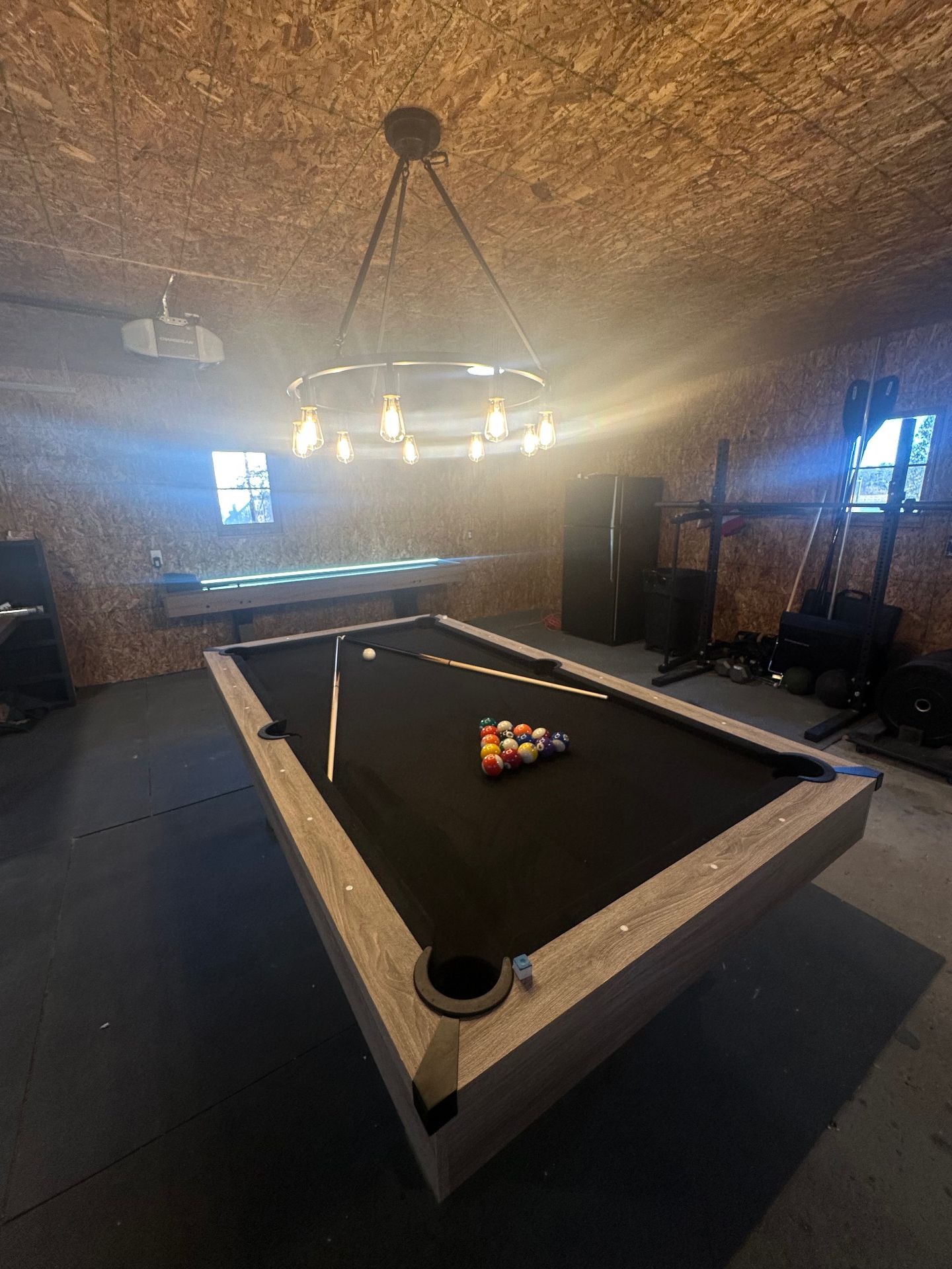 Game room at Oscoda Lakehouse with pool table, shuffleboard, and fitness equipment